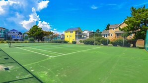 A tennis court surrounded by houses.