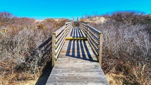 A wooden boardwalk leading to a beach, surrounded by dry vegetation. - SEA GLASS SHACK -  4 bed, 2 bath, Pool, Hot Tub & Dogs Allowed (Corolla)