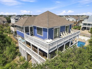 Ein mehrstöckiges Haus mit Balkon, Schwimmbad und Blick auf die Nachbarhäuser.