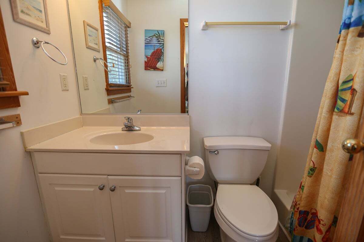 A bathroom with a sink, toilet, and a shower curtain.