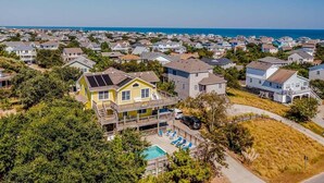 A residential area with houses, a swimming pool, and a view of the ocean. - Dunes Crest - Ocean and sound views in Duck, NC! 5 bed, 4.2 bath, pool, hot tub (Duck)
