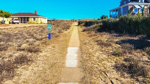 Un camino que lleva a una casa bajo un cielo azul despejado.