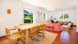 Une pièce spacieuse comprenant une table à manger en bois, des chaises, un canapé et une cheminée.
