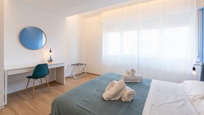A bedroom with a bed, a desk, a chair, a mirror, and a window with curtains. - Apartment 'Capitan Trinchetto Risacca' with Balcony and Wi-Fi (Trapani)