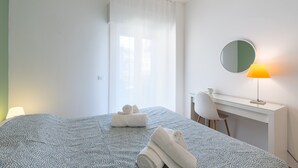 A hotel room with a bed, a desk, a chair, a lamp, and a mirror. - Apartment 'Capitan Trinchetto Agave' with Mountain View, Private Terrace and Wi-Fi (Trapani)