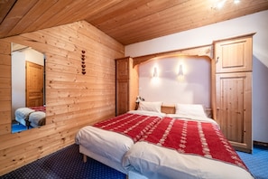 Una habitación con paneles de madera, una cama, un espejo y un armario.