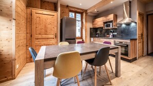 Une cuisine moderne avec des meubles en bois, un îlot central et un coin repas avec des chaises.