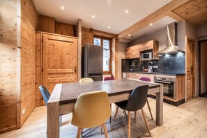 Une cuisine moderne avec des meubles en bois, un îlot central et un coin repas avec des chaises.