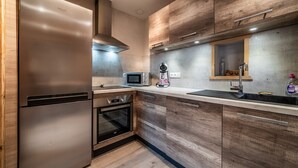 A modern kitchen with wooden cabinets, stainless steel appliances, a microwave, and a built-in oven.