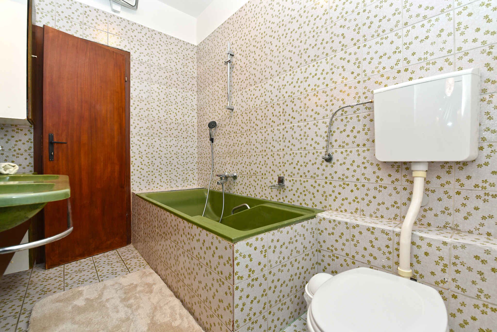 Un bagno con un lavandino verde, un WC e una doccia.