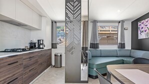 A modern kitchen with a built-in stove, a dining area with a table, and a seating area with a sofa.