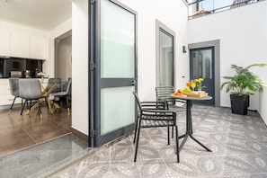 A modern kitchen with white cabinets and a dining area with a table and chairs. - Holiday Home 'Melblue' with Sea View, Private Terrace and Wi-Fi (Calheta)