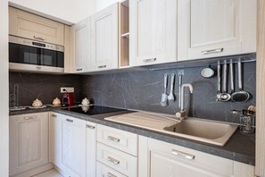 Een koelkast, een oven, een kookplaat, een koffiezetapparaat/waterkoker