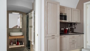Een moderne badkamer met een wastafel, spiegel, handdoekrek en een douchehoek.