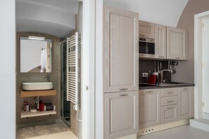A modern bathroom with a sink, mirror, towel rack, and a shower area.