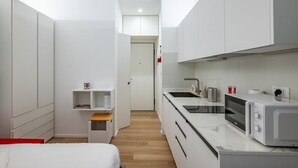 A compact kitchen with white cabinets, a microwave, and a sink. - GuestHost - Functional and modern studio apartment of approximately 17 sqm located on the ground floor of a renovated period building WITHOUT a lift (one step to access it). The apartment is located in a quiet, traffic-free street, just a 7-minute walk f (Padova)