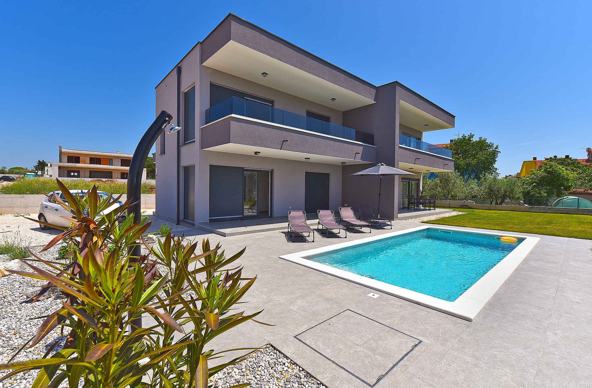 A modern two-story house with a swimming pool, outdoor seating, and a well-maintained garden.