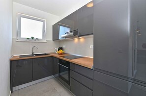 Een koelkast, een oven, een kookplaat, een vaatwasser