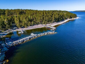 An aerial view of a coastal area with a dock, boats, and a forested peninsula. - Smultronstället by Interhome (Stavsnäs)