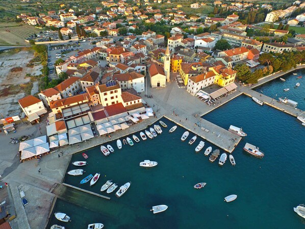 Vista aérea de un pueblo costero con un puerto deportivo, edificios e iglesia.
