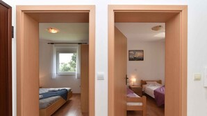 A room with a bed, a desk, and a window. - Holiday apartment with air conditioning (Medulin)