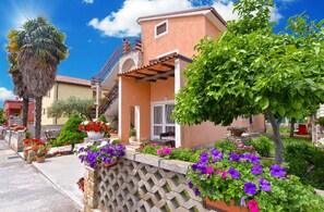 Stunning Mediterranean-style building with a charming facade, stone archway, and lush greenery.