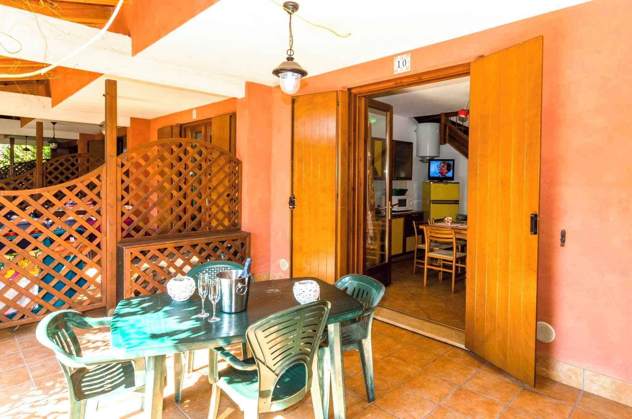 A dining area with a table set for four, surrounded by chairs, and a wooden partition with a lattice design.