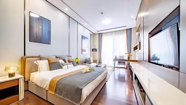 A modern hotel room with a large bed, a desk, and a TV. - Millenia Executive Apartment Guangzhou East Railway Station Zhujiang New Town Branch - Free Shuttle Bus to Canton Fair Complex During Canton Fair Period (Guangzhou)