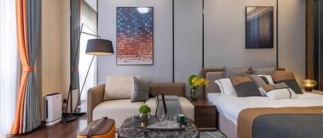 Ein modernes Hotelzimmer mit Sofa, Bett, Couchtisch und einem Bild an der Wand.