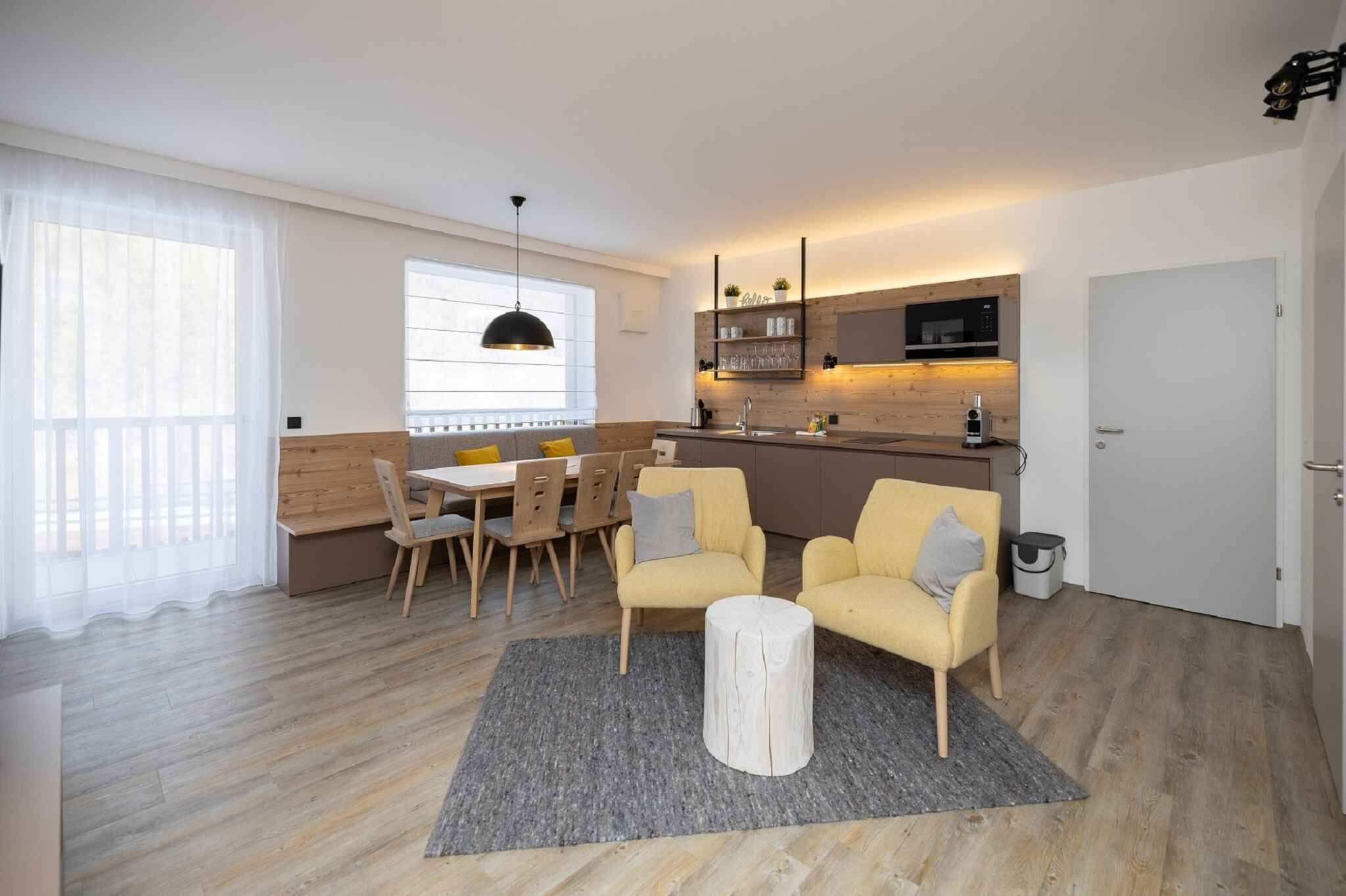 En modern lägenhet med matplats, soffa och kök.