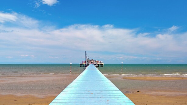 A pier extending into the sea with a building at the end. - Holiday apartment with air conditioning (Lignano)