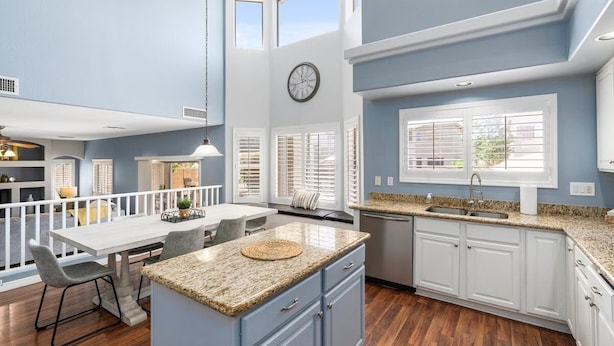 A modern kitchen with white cabinetry, granite countertops, and a dining area with a white table and chairs. - "Peaceful Avondale Escape – Pool, Hot Tub, Outdoor Living!" (Avondale)