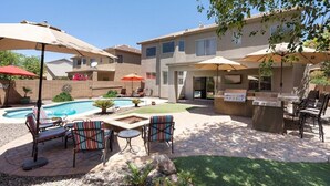 A backyard with a swimming pool, patio furniture, and a barbecue area. - "Peaceful Avondale Escape – Pool, Hot Tub, Outdoor Living!" (Avondale)