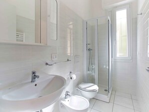 Une salle de bain moderne avec un lavabo, des toilettes et une douche à parois de verre.