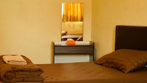 A hotel room with a bed, a nightstand, a mirror, and a window with curtains. - The House Hostel (Bangkok)