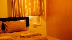 A neatly made bed with a headboard, pillows, and a blanket. - The House Hostel (Bangkok)