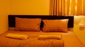 A bed with a dark headboard, two pillows, and a neatly folded blanket. - The House Hostel (Bangkok)