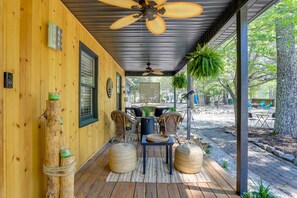 A covered porch with wooden flooring, wicker furniture, and a ceiling fan. - Deck & Hiking Trails: Luxe Georgia Farm Retreat (Lithonia)