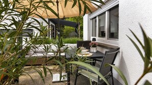 Eine Terrasse mit Tisch, Stühlen und einer Couch.
