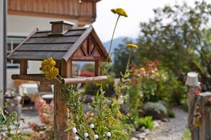 A wooden birdhouse with a roof and a hanging yellow flower. - Apartment 'Haus Rosenheim' with Mountain View, Balcony and Wi-Fi (Ramsau am Dachstein)