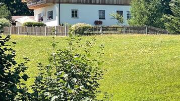 Ein zweistöckiges Haus mit rotem Dach, Holzfassade und einem Balkon.