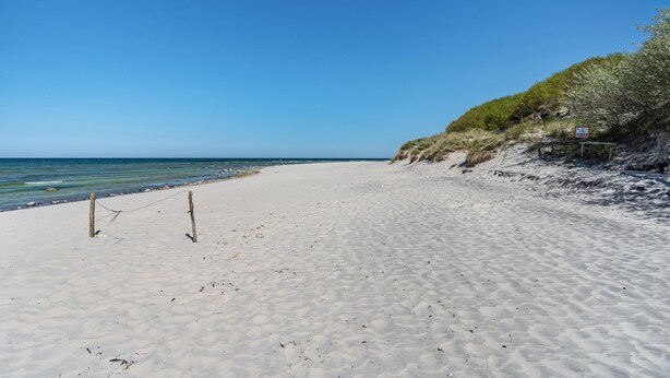 A beach with a clear sky, a sandy shore, and a sign indicating a restricted area. - Bungalow 'Bungalow Kay, Bgl  4' with Private Terrace and Wi-Fi (Dranske)