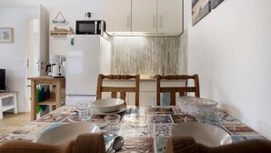 Una cocina compacta con microondas, refrigerador y armarios de madera.