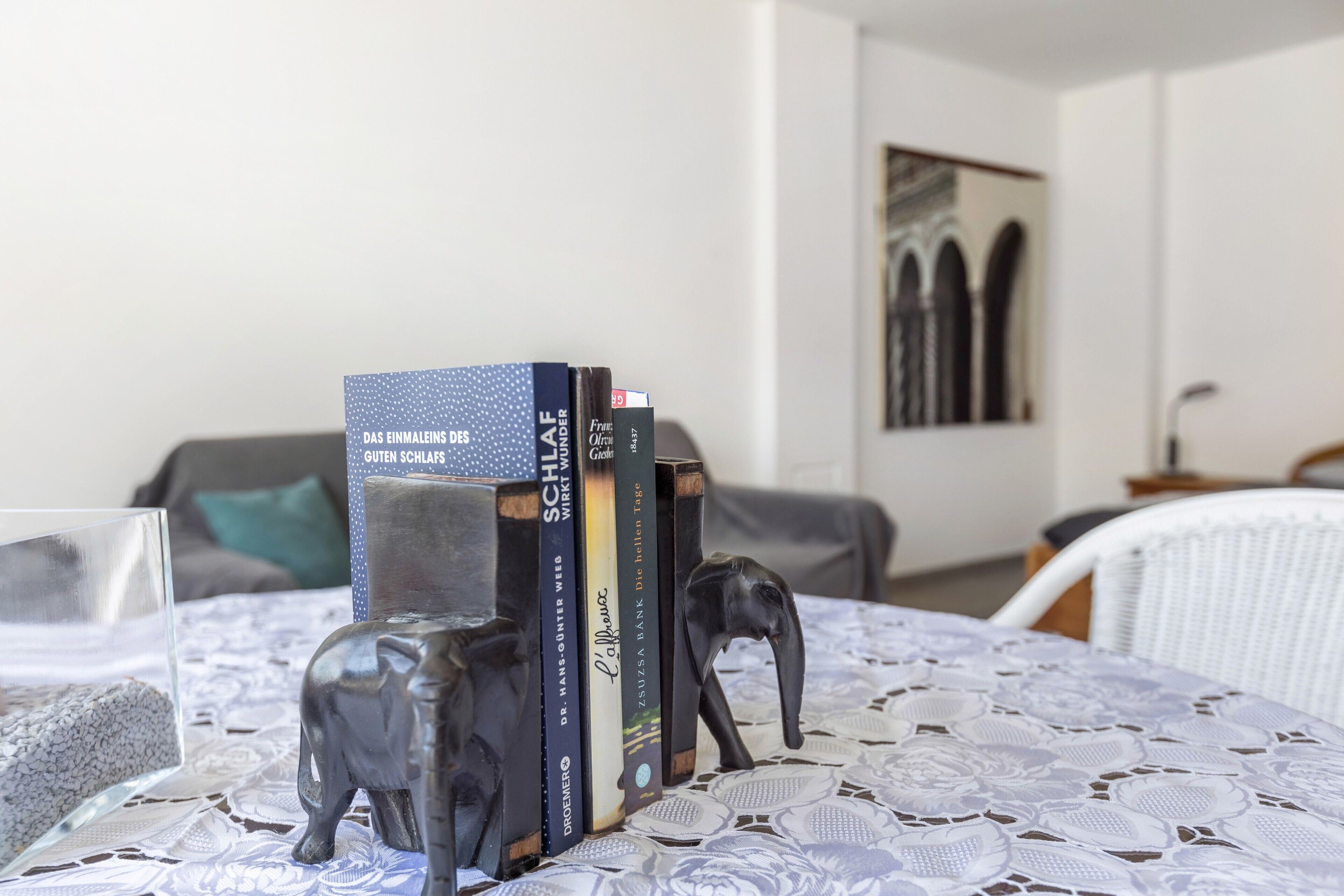 A room with a table displaying books and a decorative elephant figurine.