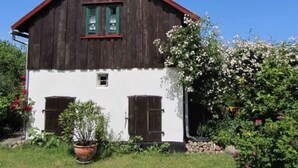 A two-story wooden house with a red roof, white walls, and green shutters. - Holiday Home 'Villa Ilsebill' with Private Terrace and Garden (Ribnitz-Damgarten)