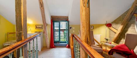 A wooden staircase leading to a door with a view of greenery outside.