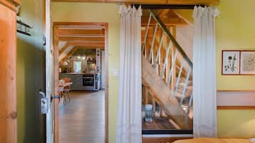 An interior view of a rustic wooden room with a staircase leading to an upper level.