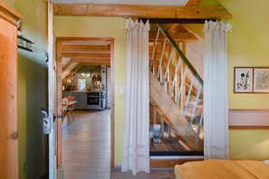 An interior view of a rustic wooden room with a staircase leading to an upper level.