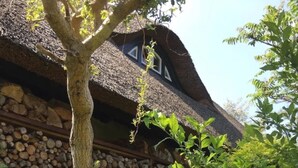 Ein rustikales Gebäude mit einer Steinwand und einem Strohdach.
