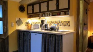 A compact kitchen with a built-in dishwasher, a coffee maker, and a sink. - Holiday Home 'Charlottes Landlust' with Private Terrace and Garden (Ribnitz-Damgarten)